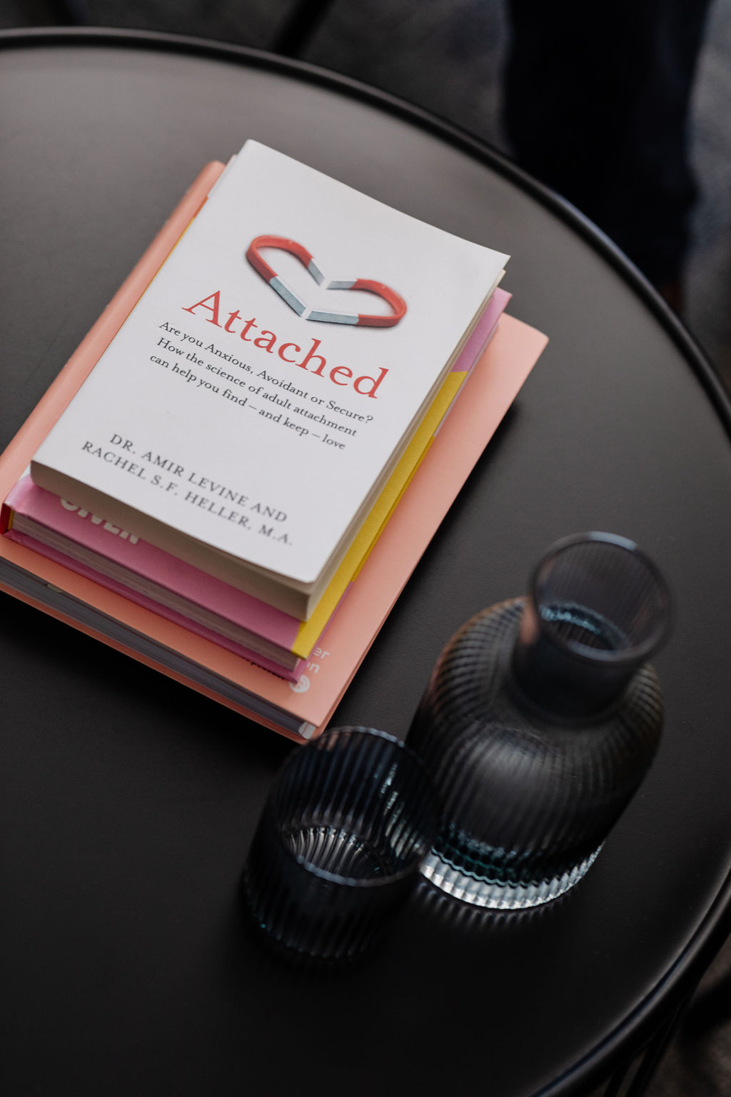 A selection of psychology self-help books stacked on a coffee table